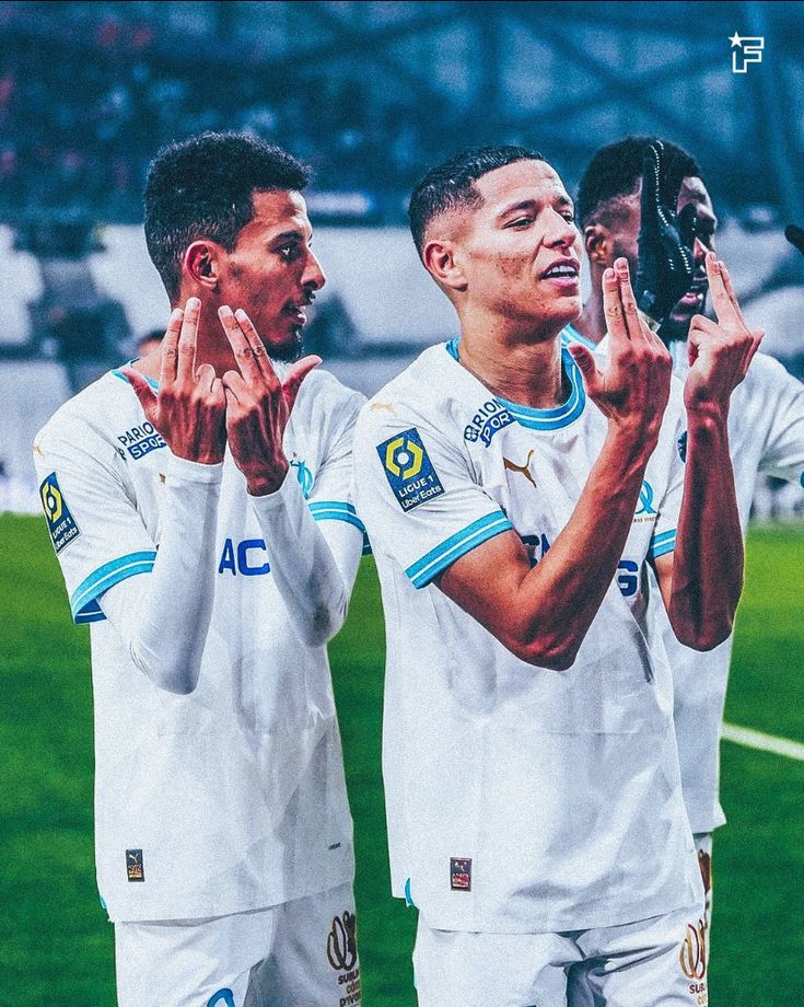 two soccer players applauding each other at the end of a game with their hands in the air