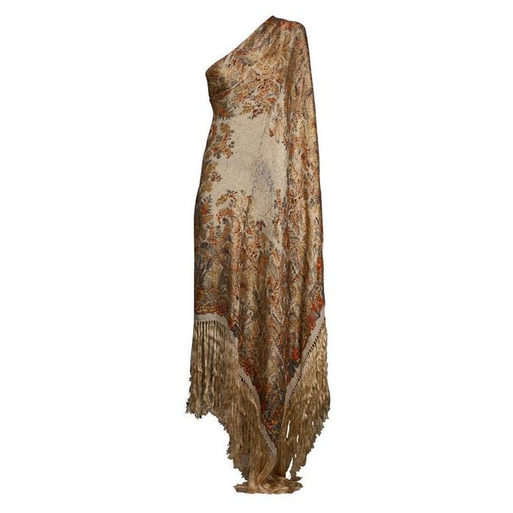 a women's shawl with fringes and flowers on the bottom, draped over it