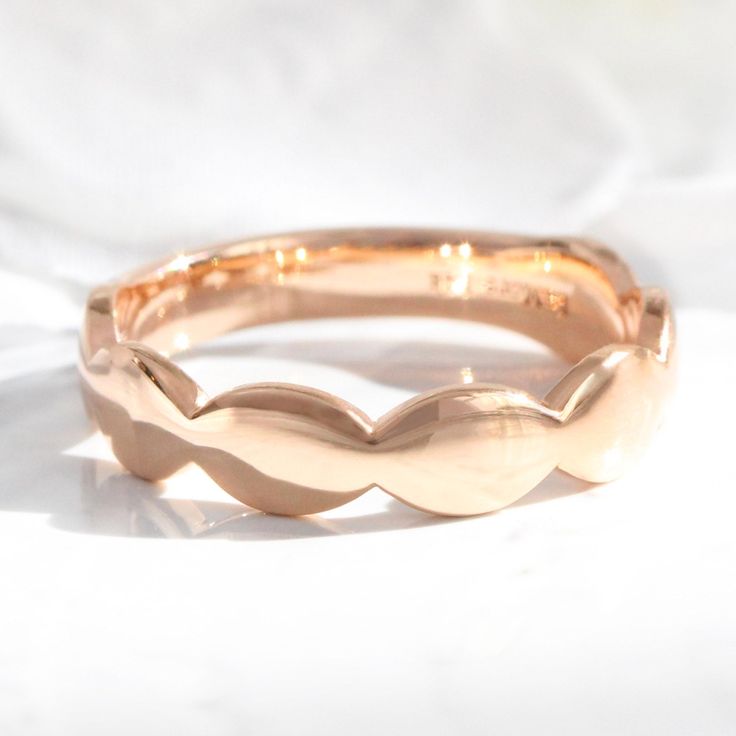 a gold ring with wavy edges on a white background