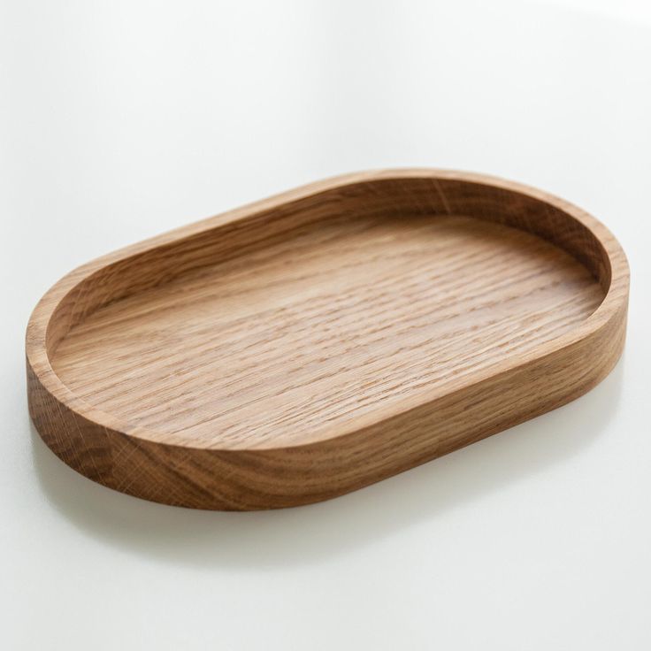 an oval wooden tray on a white surface