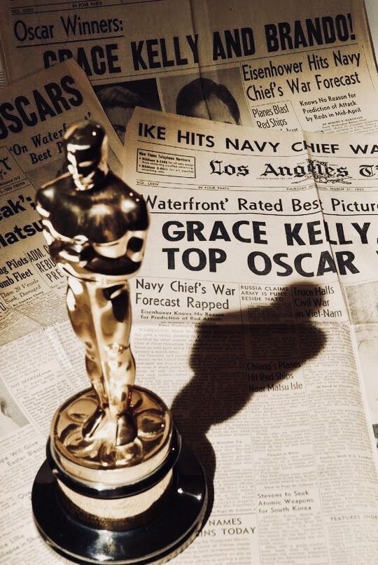 an oscar statue sitting on top of a newspaper