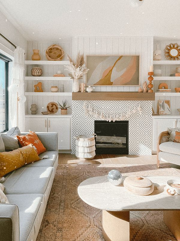 a living room filled with furniture and a fire place in front of a large window