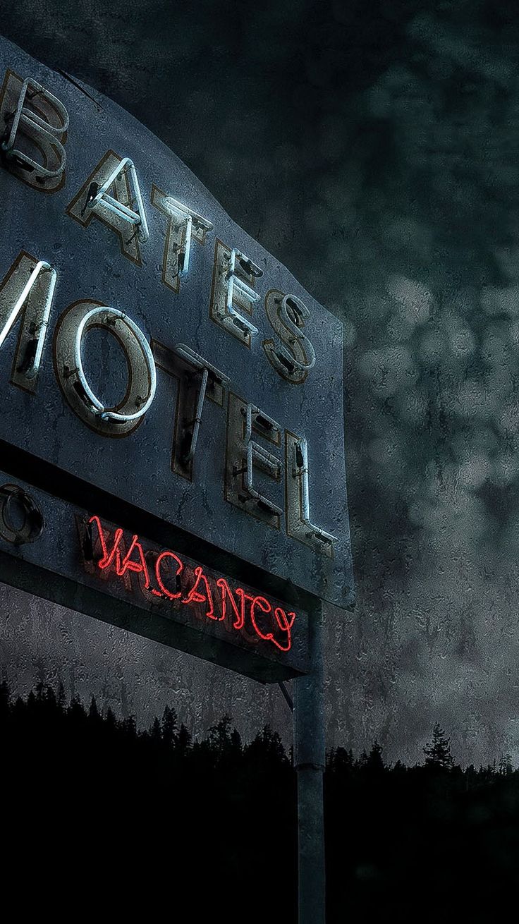 an old motel sign lit up at night with the word bates motel on it