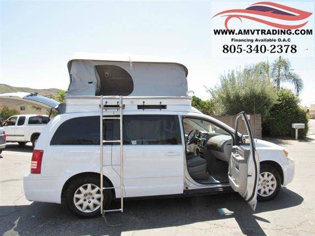 a white van parked in a parking lot with its doors open and the back door opened