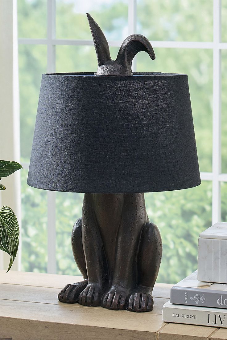 a cat lamp sitting on top of a table next to a window