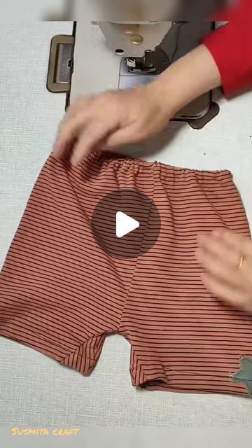 someone is using a sewing machine to sew a pair of striped shorts with buttons
