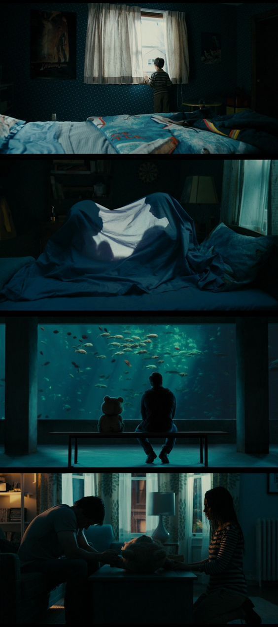 two people sitting at a table in front of a fish tank and under the bed