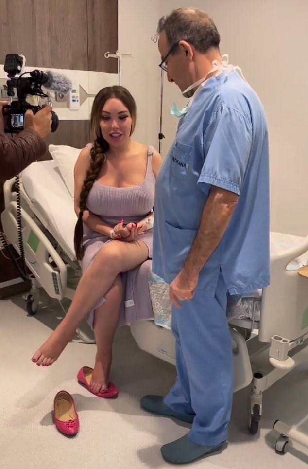 a woman sitting on a hospital bed next to a man in a blue scrub suit