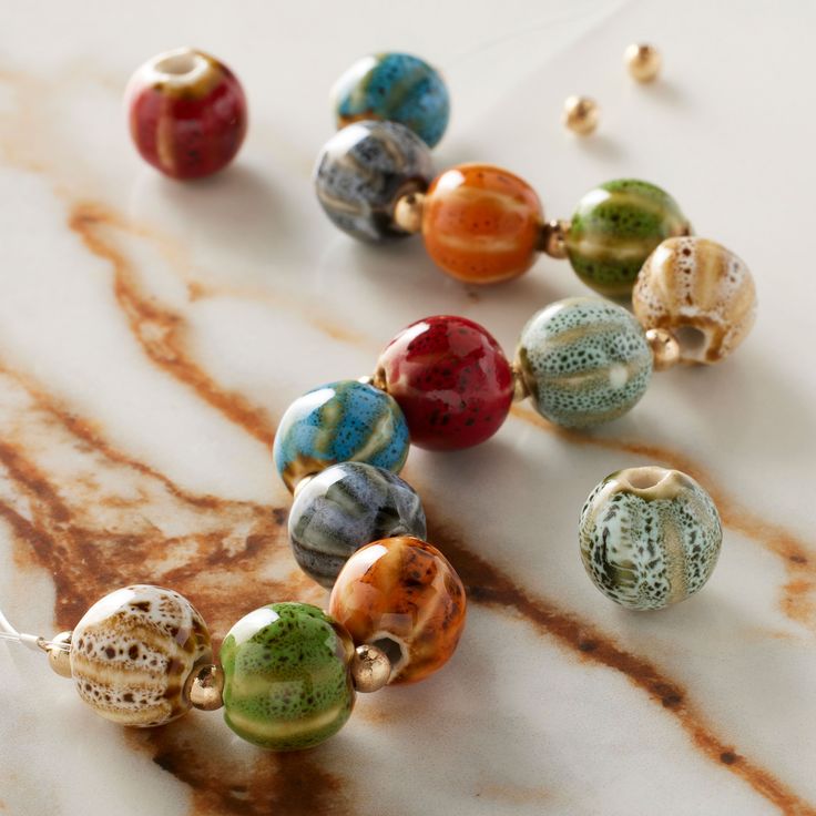 several different colored glass beads on a marble surface