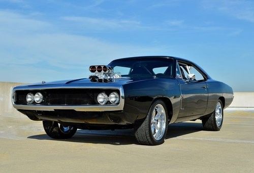 an old muscle car is parked in a parking lot