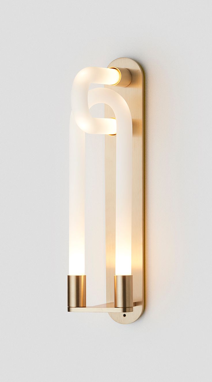 a light that is on the side of a wall with a white and gold color