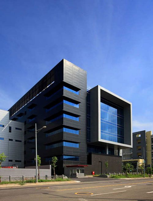 an office building with many windows on the front and side of it's face