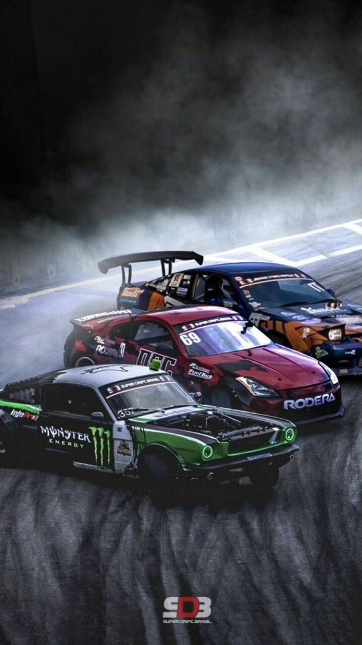 three cars racing on a track in the dark