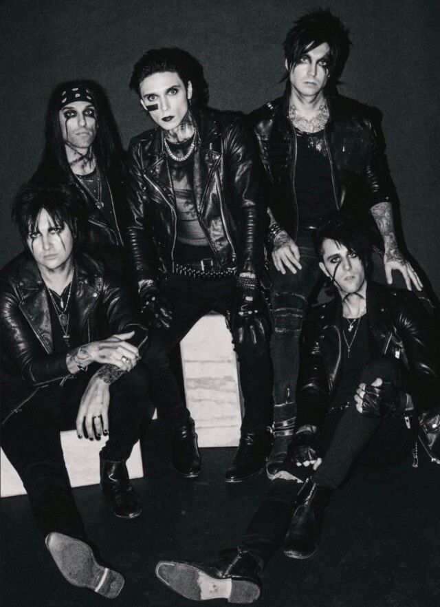 the group of punk rockers posing for a black and white photo