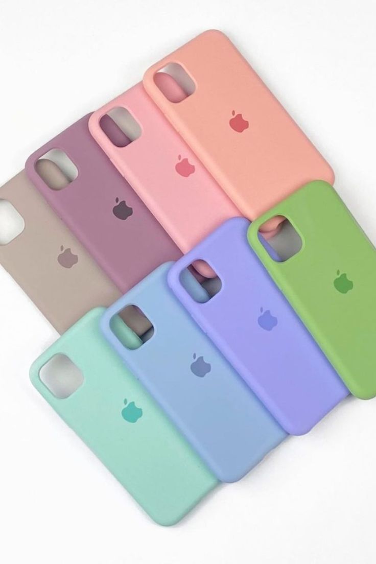 six different colored iphone cases sitting next to each other on a white surface with an apple logo in the middle
