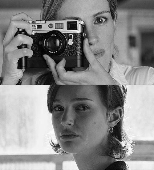 a woman holding up a camera to her face