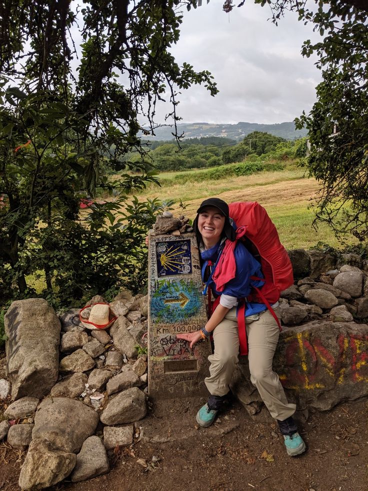 a person with a backpack sitting next to a sign