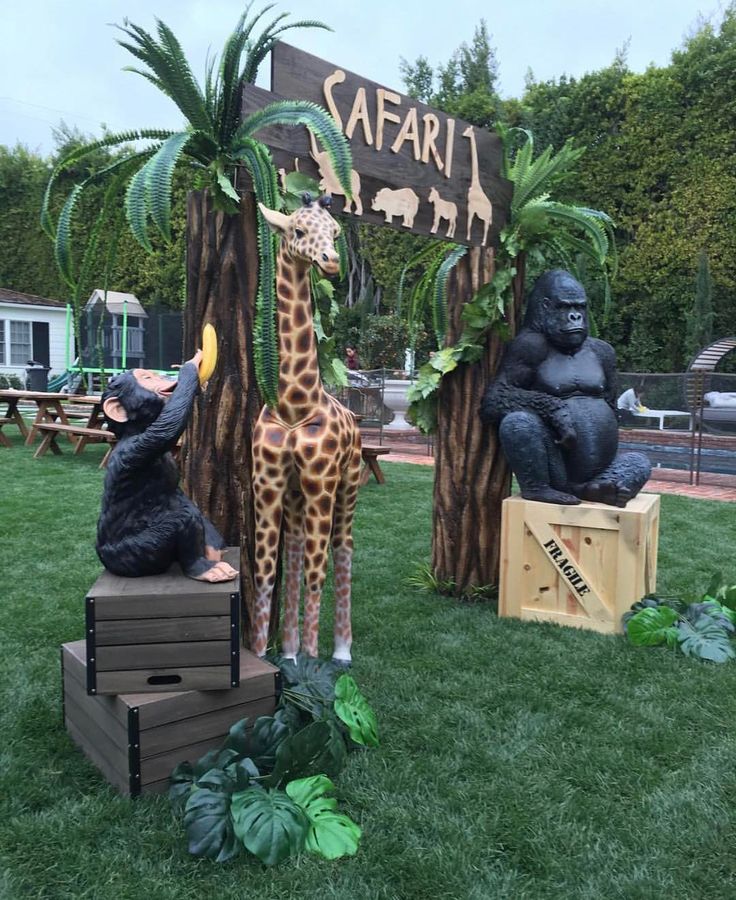 some fake animals are sitting in front of a sign that says safari and two gorillas