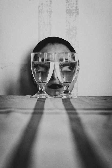 the reflection of two glasses in front of a mirror