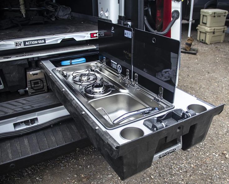 an open camper with a stove and sink in the back