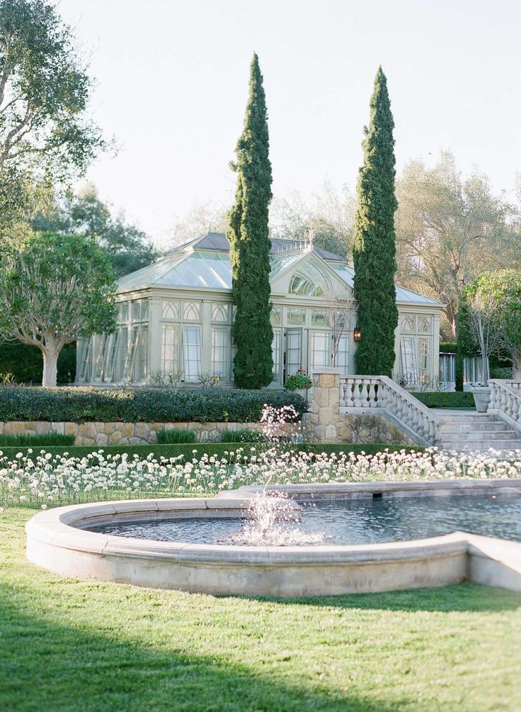 a large house with a fountain in front of it