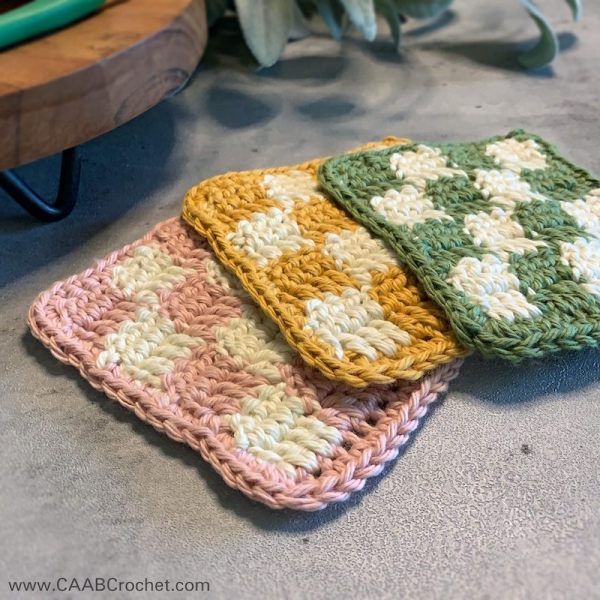 three crocheted dishcloths sitting on top of a table