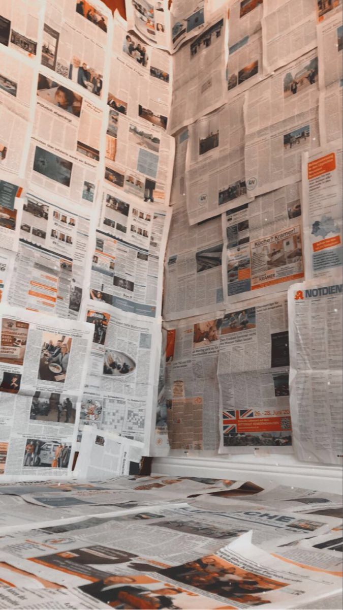 newspapers are stacked on top of each other with orange and black images all over them