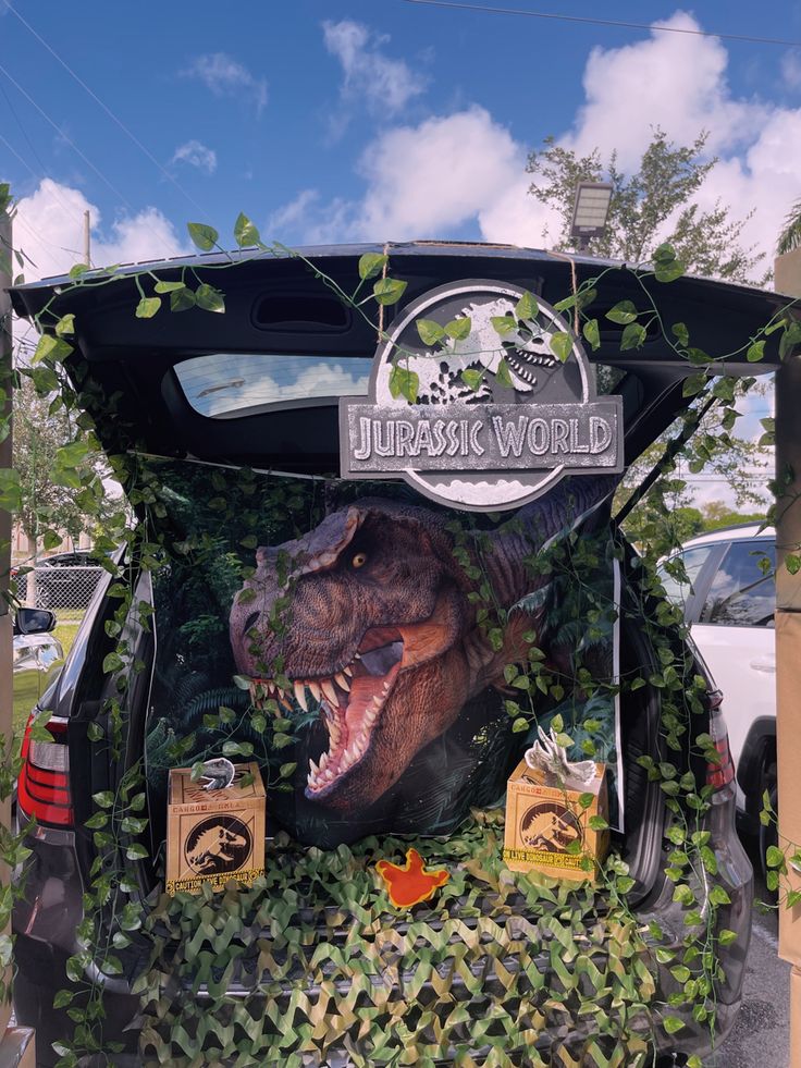 the back end of a car decorated with an image of a dinosaur