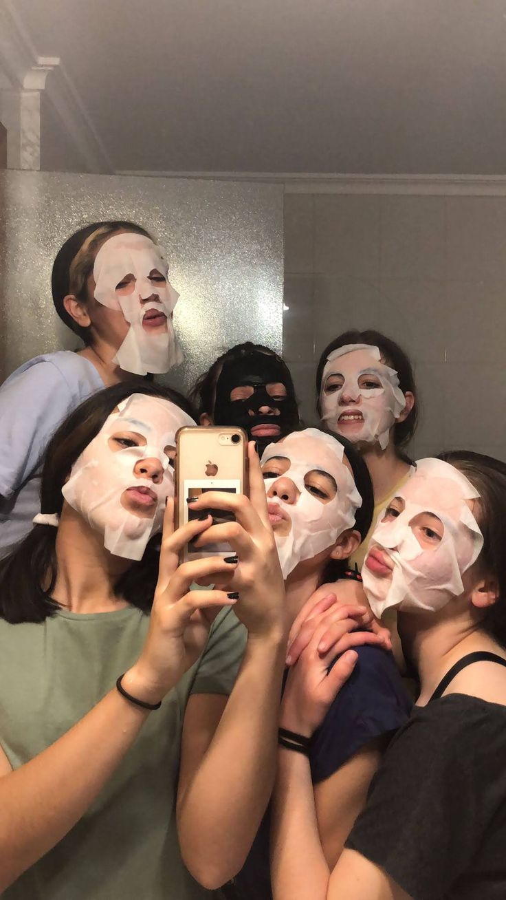 a group of people with facial masks on taking a selfie