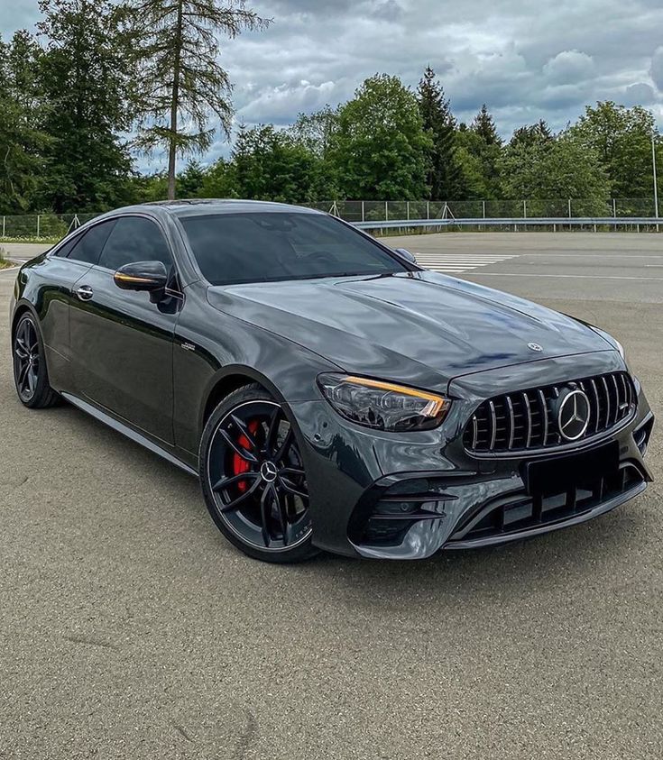 the mercedes amg coupe is parked in a parking lot with trees in the background