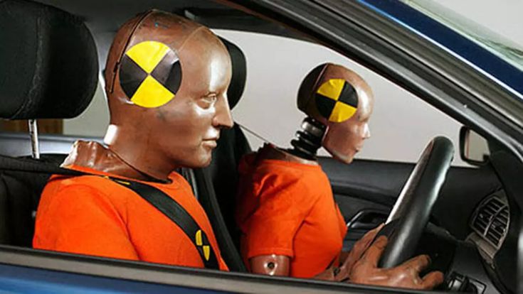 two mannequin heads sit in the driver's seat of a car