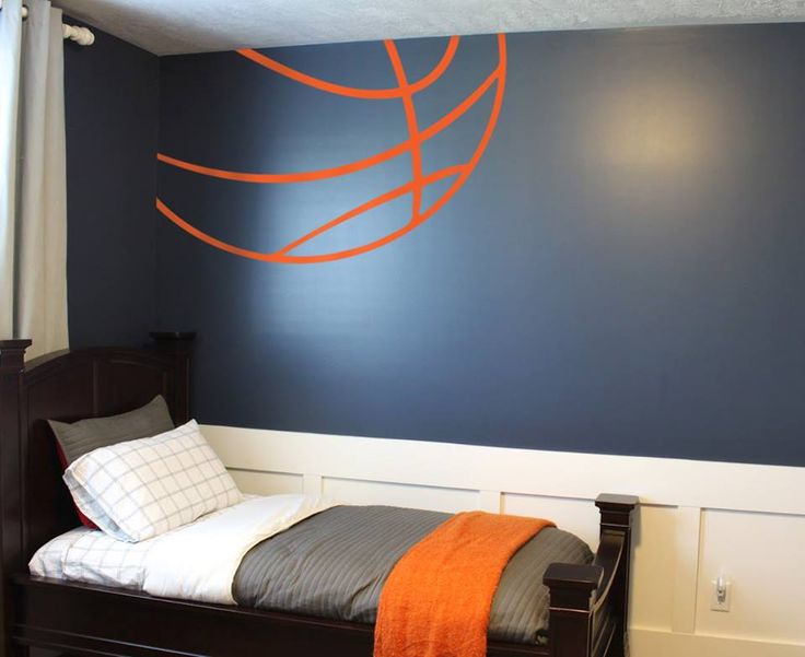 a bedroom with blue walls and a basketball painted on the wall