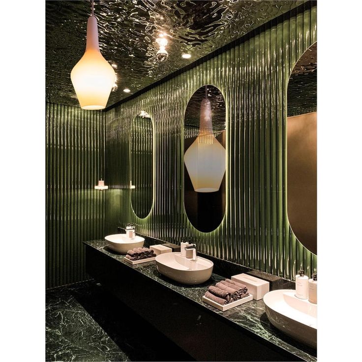 a bathroom with two sinks and three mirrors on the wall, one is green and the other is white