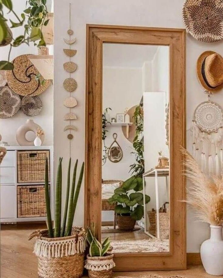 a mirror sitting on top of a wooden floor next to potted plants and baskets