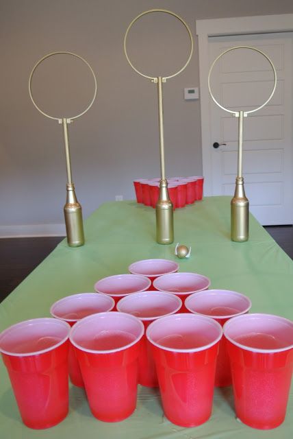 red plastic cups sitting on top of a green table covered in gold circles and poles