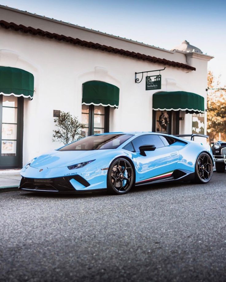 a blue sports car parked in front of a building