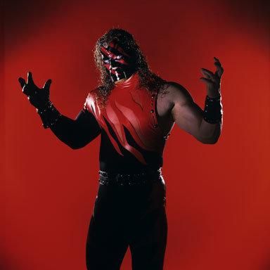 a man dressed in black and red with his hands out, posing for the camera