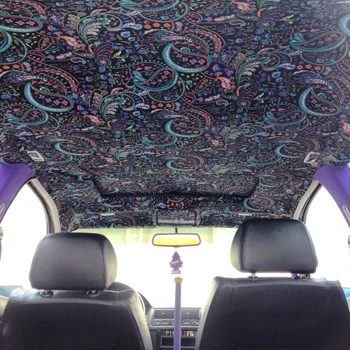 two seats in the back of a van with an intricately designed carpeted ceiling