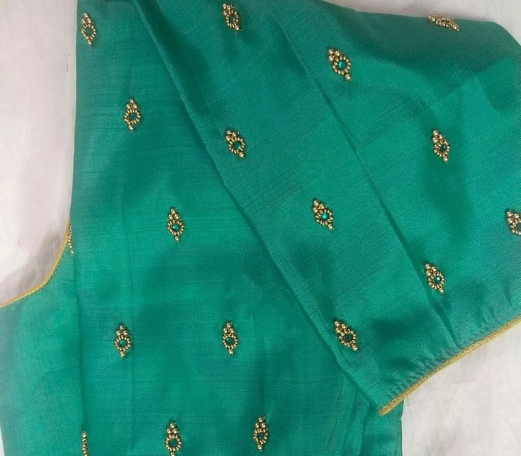 a green sari with gold thread work on it
