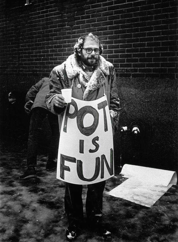 a man holding a sign that says pot is fun