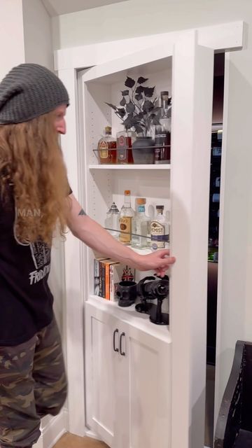 a woman standing in front of a white cabinet