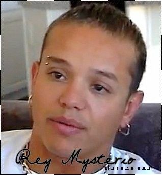 a young man is looking at the camera while wearing a white shirt and silver necklace