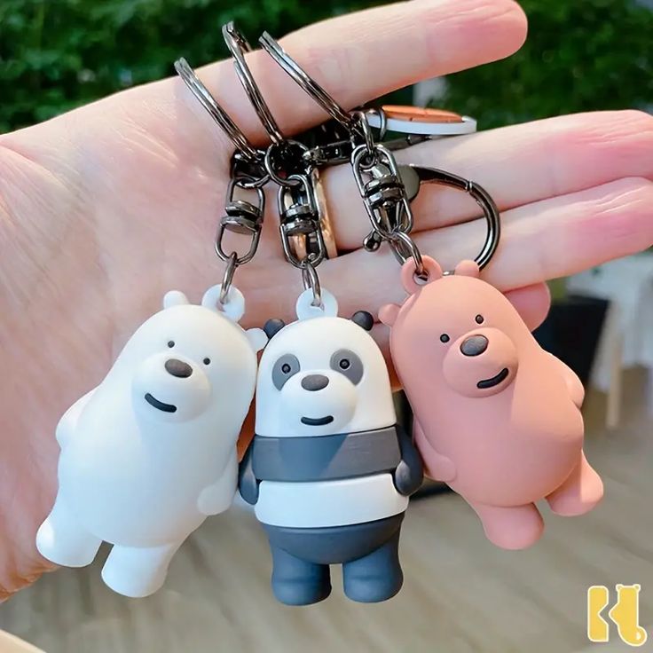 three cartoon keychains are being held in the palm of someone's hand