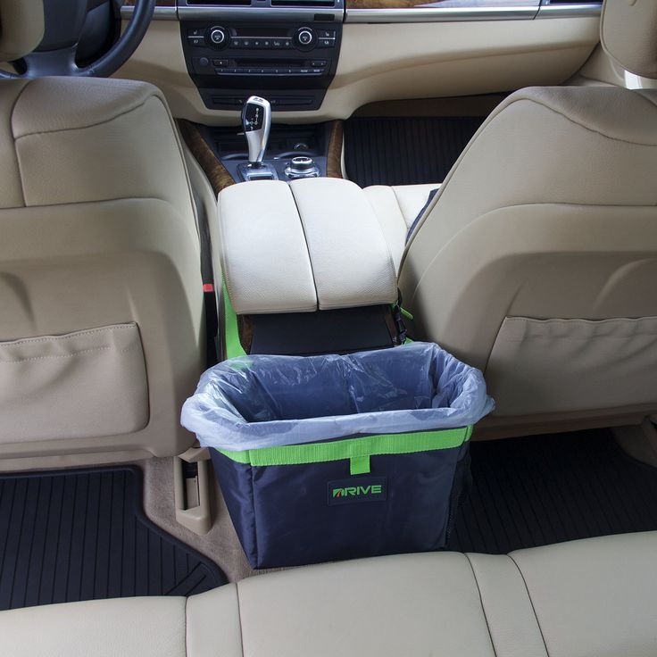 the back seat of a car with a blue and green basket in it's center console