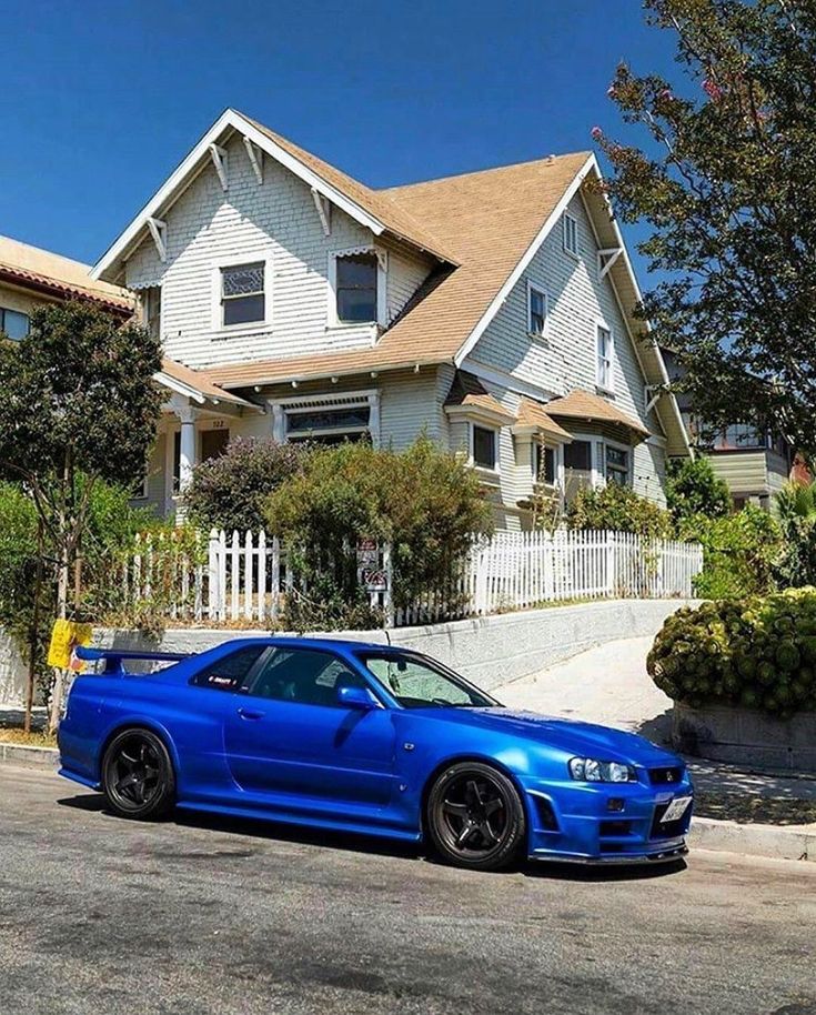 a blue car parked in front of a house