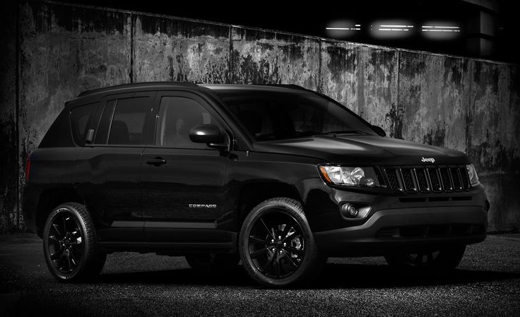 a black jeep parked in front of a concrete wall