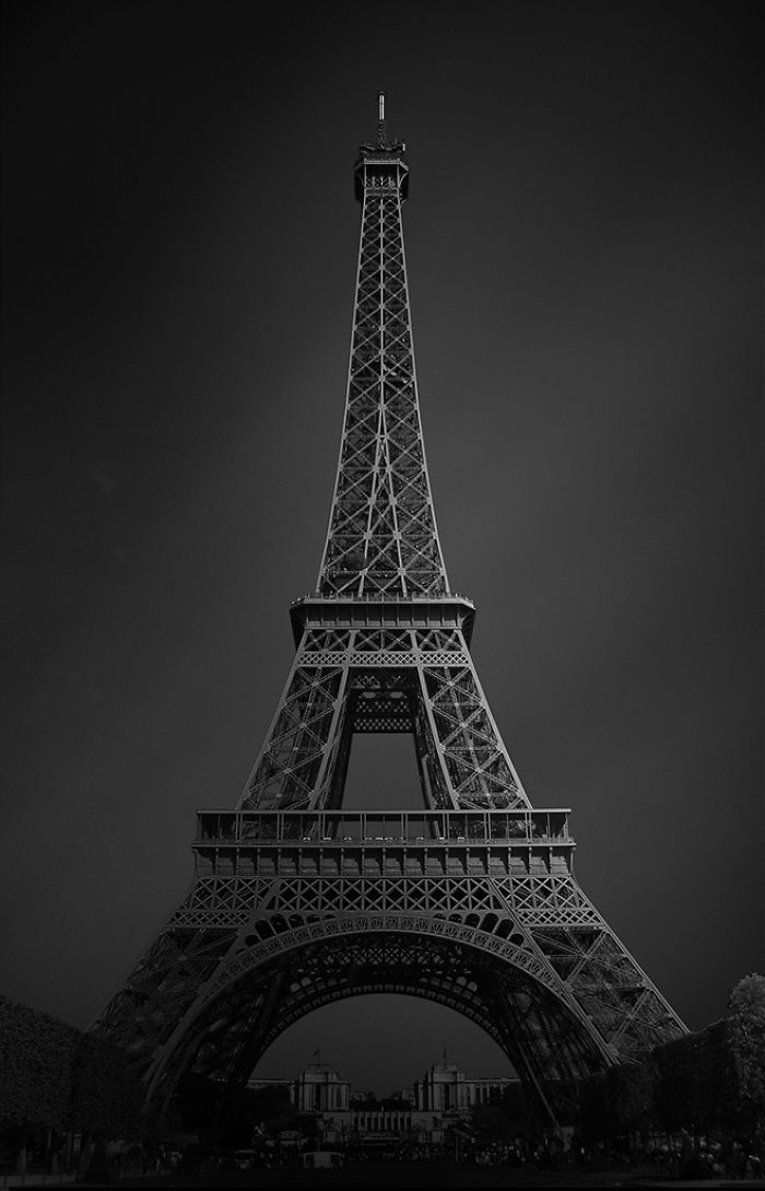 the eiffel tower in black and white is lit up with lights on it