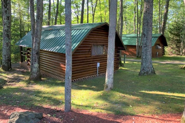 two cabins in the woods with trees and rocks