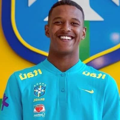 a young man is smiling in front of a sign