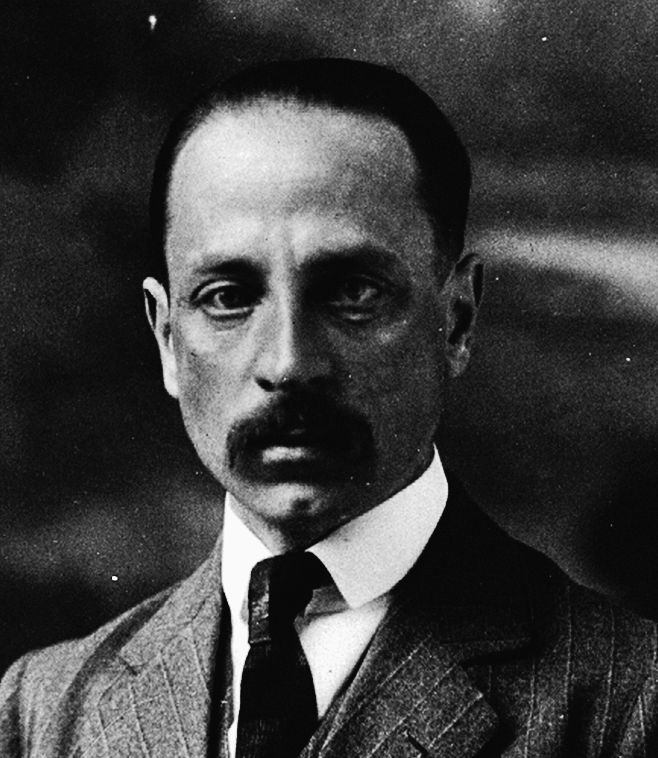 an old photo of a man in a suit with a moustache on his face